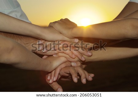 Friendly family hands closeup against the sunset