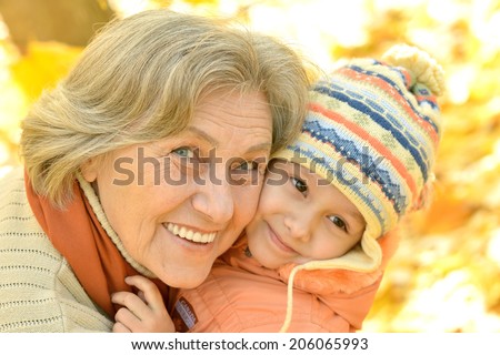 Grandmother with her granddaughter for a walk during the fall of the leaves in the park
