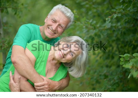 Happy Senior man hugging senior woman in summer forest