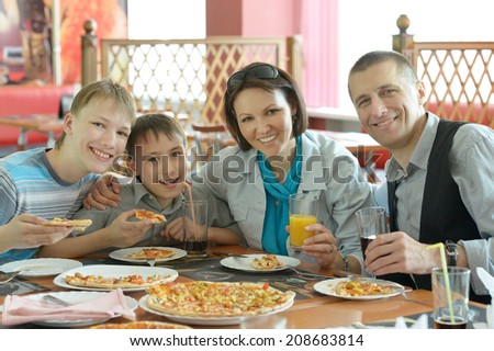 Portrait of smiling family eating pizza in cafe