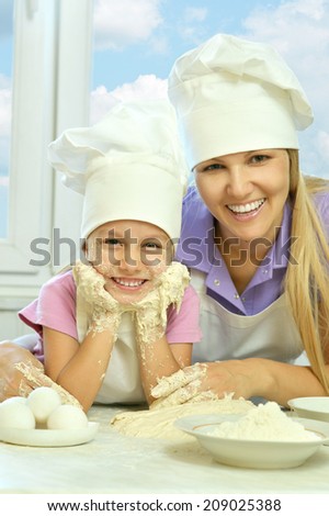 Adorable mother and daughter cooking together in the kitchen