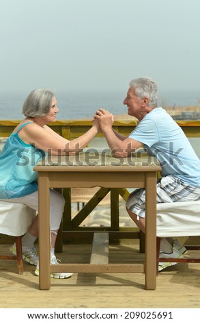 Senior couple sitting at table at beach
