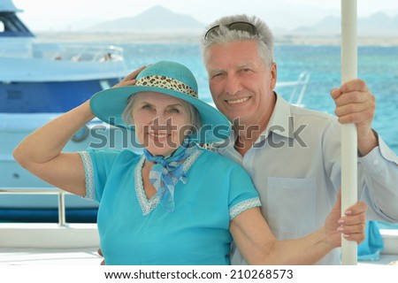 Smiling elderly couple have a ride in a boat on sea