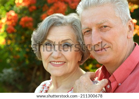 Happy senior couple on background with flowers