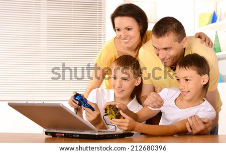 Happy family playing video games on loptop