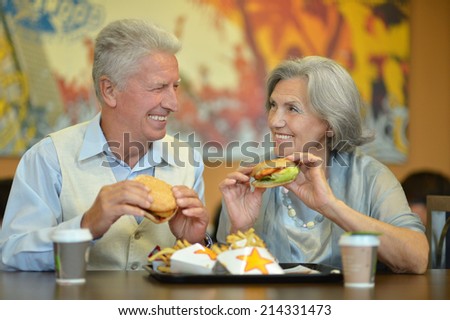 Portrait of beautiful elderly couple eating fast food