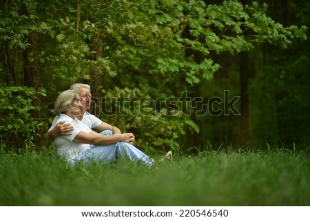 Beautiful happy old people sitting in forest