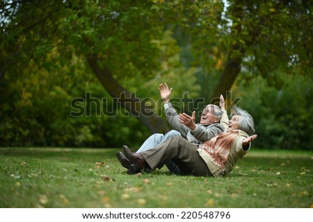 Beautiful happy old people sitting in the autumn park