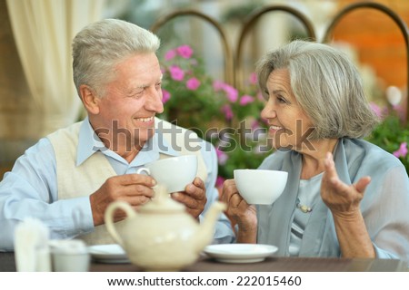 Happy beautiful older couple drink coffee together