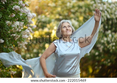 Smiling beautiful older woman with white flowers