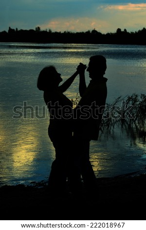 Happy Mature couple dance at twilight near river
