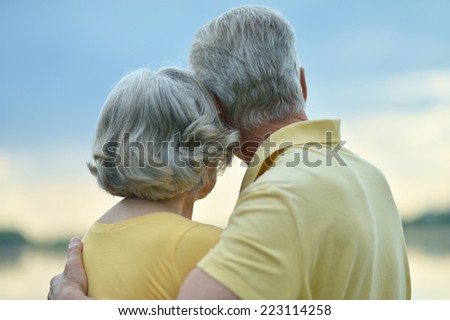 Happy senior couple near lake,back view