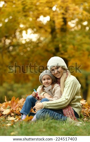 Happy mother with her cute daughter in autumn park
