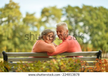 Happy old couple posing at autumn park