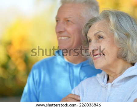Happy old couple posing at autumn park