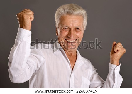 Portrait of happy senior man on grey background