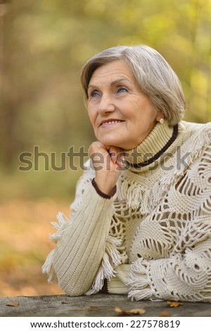 Beautiful happy old woman in the autumn park