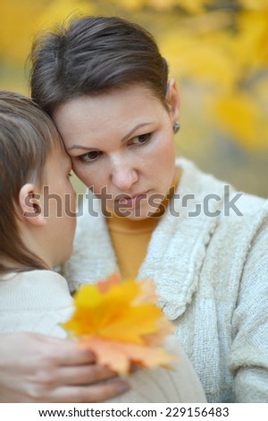 Sad mother with a son in the autumn park