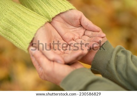 Elderly couple holding hands in autumn park