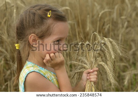 Little girl running with bunch of wheat