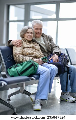 Senior couple at airport sitting on bench