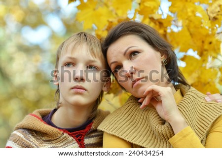 Sad mother with a son in the autumn park
