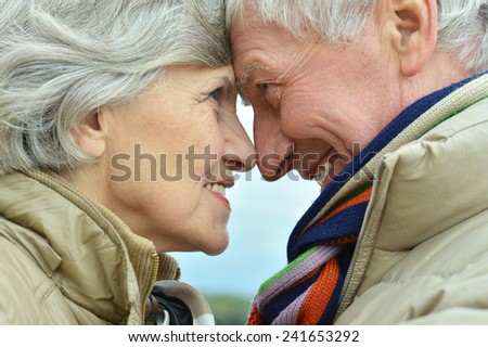 Happy elderly couple sitting in autumn nature
