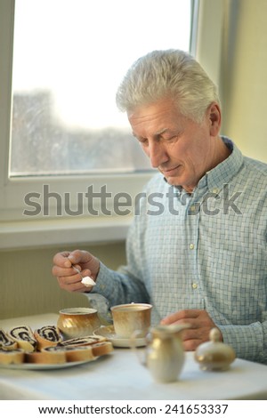 Beautiful elderly man at home with cup of tea