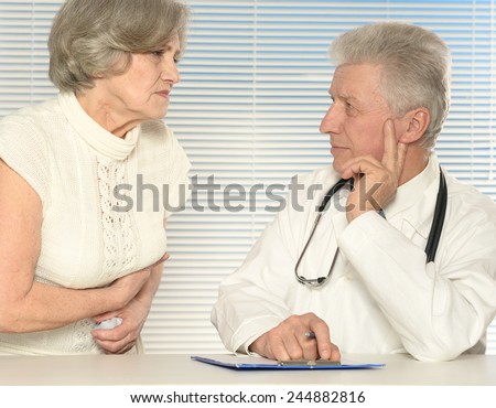 Caucasian nice old doctor with a patient on a light background
