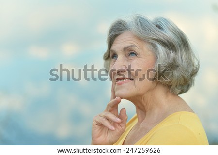Portrait of a beautiful mature woman on the background of sky