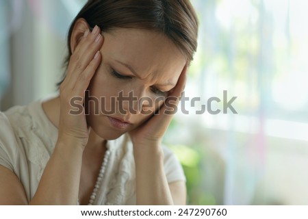 Sick woman with headache at home