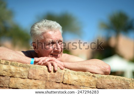 Senior man swimming in pool at resort