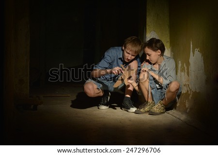 Little boys in a dark cellar with toy plane