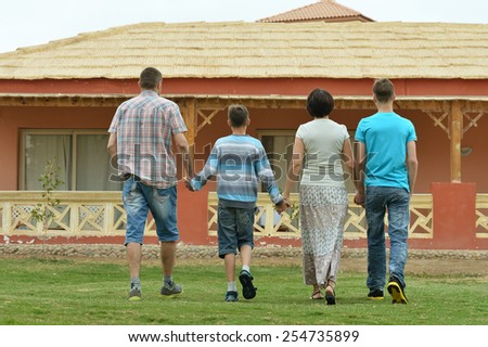 Happy family in tropical ressort,back view