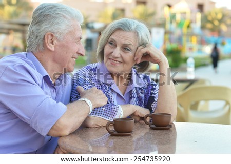 Senior couple drinking coffee outside at the resort during vacation