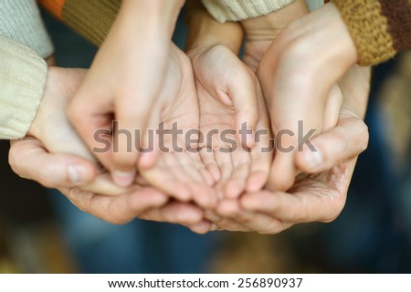 Hands held together on a natural background