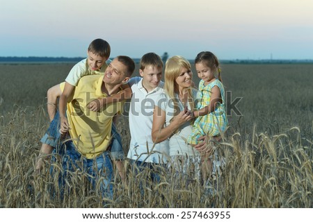 Portrait of a family walking in field in evening