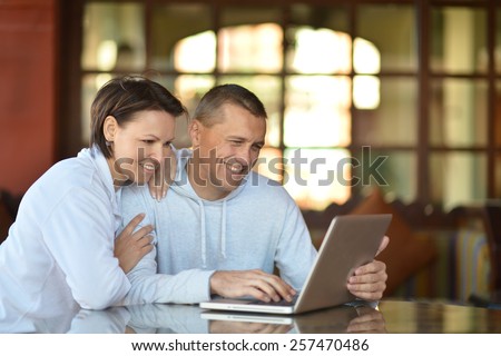 Happy couple with laptop at the table
