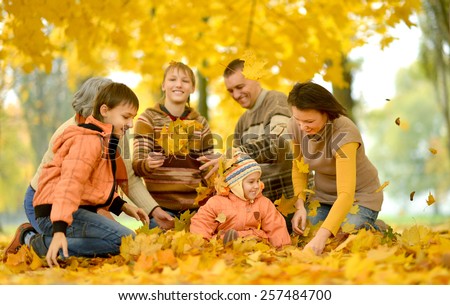 Friendly family on a walk during the fall of the leaves in the park