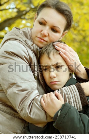 Sad mother with son on walk during the fall in the park