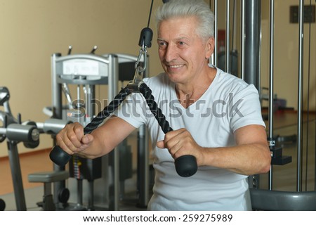 Elderly man doing sports in a gym