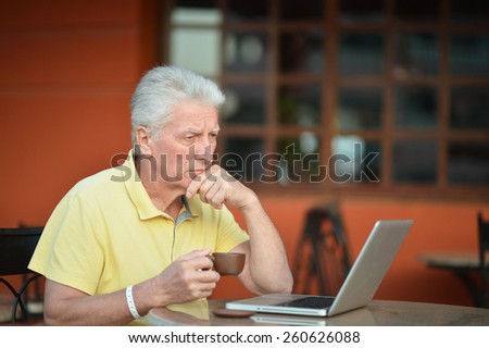 Senior man sitting with laptop in hotel