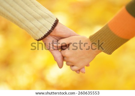Hands of people of different ages in the autumn park