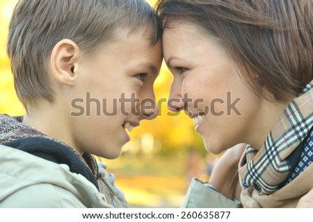 Sad mother with a son on a walk during the fall of the leaves in the park