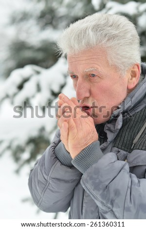 Senior man standing outdoor in winter with thumbs up