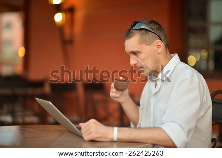 Portrait of a happy Man with laptop on table