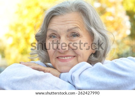 Portrait of a happy happy senior woman in autumn park
