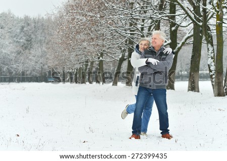 Portrait of elderly couple having fun outdoors in winter forest