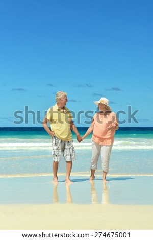 Beautiful happy elderly couple walking along the seashore