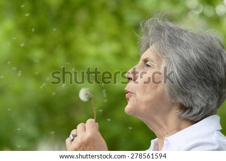 Portrait of an elderly woman on a walk in the park in late spring